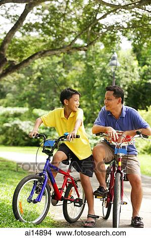 Father and son on bicycle, looking at each other View Large Photo Image Picture - Father and son on bicycle, looking at each other. Fotosearch