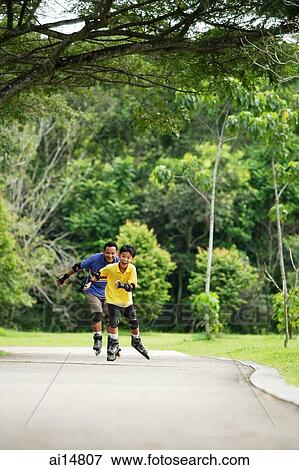 Father and son on roller blades, skating in park View Large Photo Image Stock Photo - Father and son on roller blades, skating in park. Fotosearch
