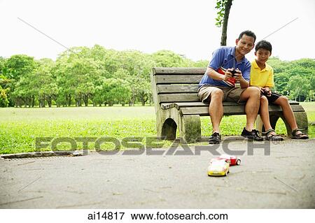 Stock Photo - Father and son playing with remote control cars. Fotosearch
