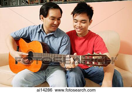 Father and son side by side, father holding guitar View Large Photo Image Stock Photograph - Father and son side by side, father holding guitar. Fotosearch