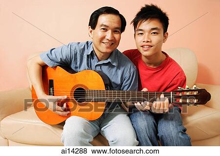 Father and son side by side, holding guitar, looking at camera View Large Photo Image Stock Photo - Father and son side by side, holding guitar, looking at camera. Fotosearch