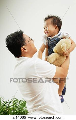 Father carrying young daughter up, smiling View Large Photo Image Stock Photography - Father carrying young daughter up, smiling. Fotosearch