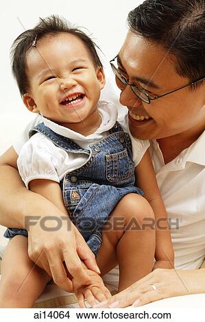 Father holding young daughter, smiling View Large Photo Image Picture - Father holding young daughter, smiling. Fotosearch