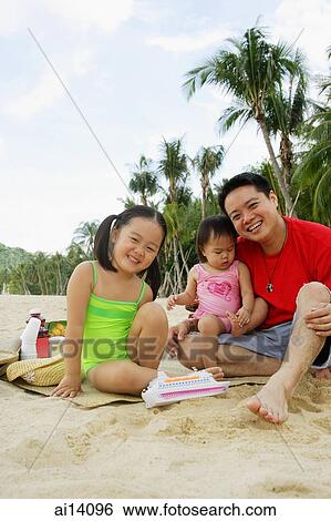 Father with two children on beach, looking at camera View Large Photo Image Stock Photograph - Father with two children on beach, looking at camera. Fotosearch
