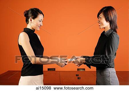 Stock Photo - Female executive giving namecard to another executive. Fotosearch