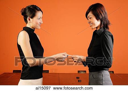 Stock Photo - Female executives exchanging namecards. Fotosearch