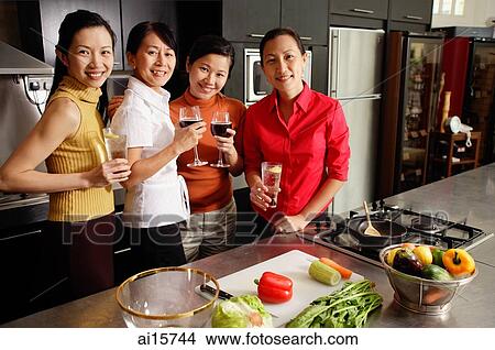 Four women in kitchen, holding wine glasses, smiling at camera View Large Photo Image Picture - Four women in kitchen, holding wine glasses, smiling at camera. Fotosearch