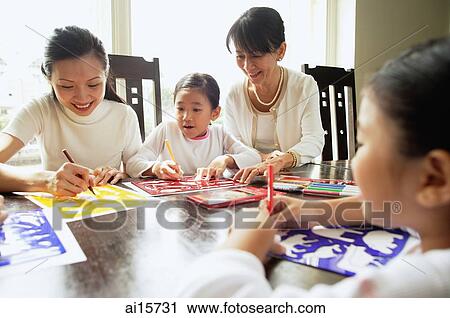 Stock Image - Grandmother and mother with two girls, drawing. Fotosearch