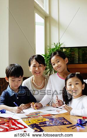 Picture - Grandmother watching grandchildren colouring. Fotosearch