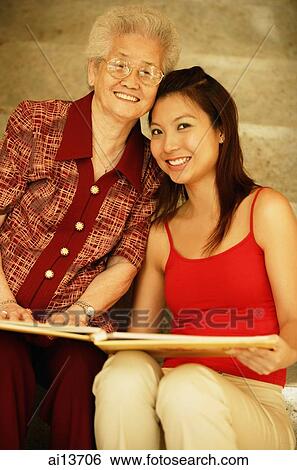 Grandmother with granddaughter, holding picture album View Large Photo Image Stock Photograph - Grandmother with granddaughter, holding picture album. Fotosearch