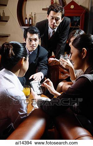 Picture - Group of executives having a discussion over drinks. Fotosearch