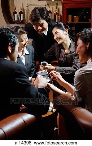 Group of young executives using PDA, having discussion View Large Photo Image Stock Photograph - Group of young executives using PDA, having discussion. Fotosearch