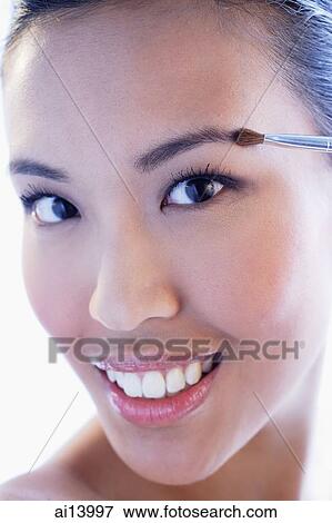 Headshot of woman using make-up brush View Large Photo Image Stock Photo - Headshot of woman using make-up brush. Fotosearch