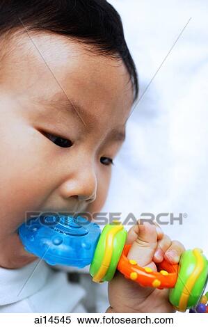 Infant boy biting toy, close-up View Large Photo Image Stock Photography - Infant boy biting toy, close-up. Fotosearch