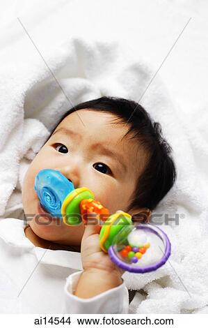 Infant boy biting toy View Large Photo Image Picture - Infant boy biting toy. Fotosearch