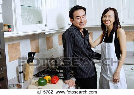 Man and woman standing in kitchen, smiling at camera View Large Photo Image Stock Image - Man and woman standing in kitchen, smiling at camera. Fotosearch
