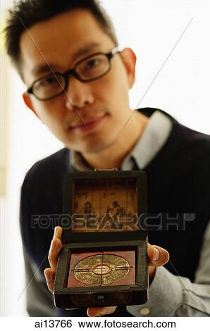 Man holding Chinese compass View Large Photo Image Stock Photograph - Man holding Chinese compass. Fotosearch