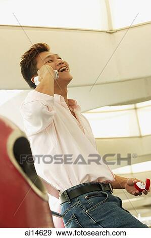 Man holding ring box, using mobile phone, smiling View Large Photo Image Stock Photo - Man holding ring box, using mobile phone, smiling. Fotosearch