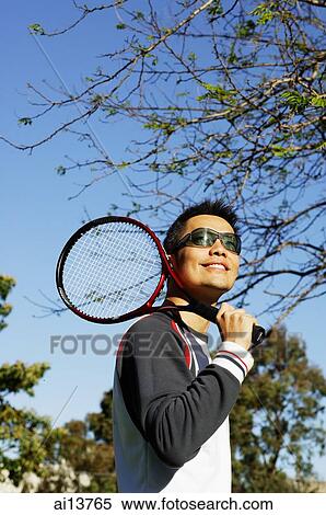 Man holding tennis racket over shoulder View Large Photo Image Stock Photography - Man holding tennis racket over shoulder. Fotosearch