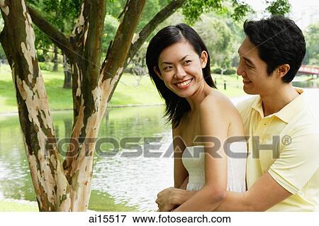 Man hugging woman from behind View Large Photo Image Stock Photo - Man hugging woman from behind. Fotosearch