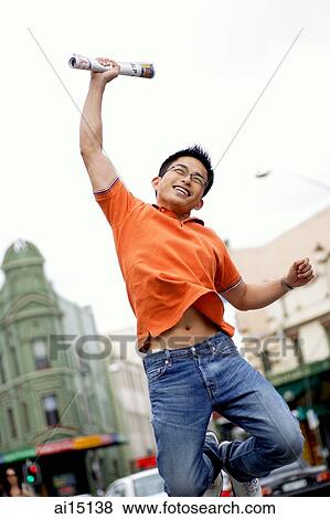 Man jumping in air, holding newspaper in raised arm View Large Photo Image Stock Photo - Man jumping in air, holding newspaper in raised arm. Fotosearch