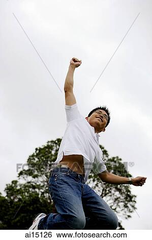 Man jumping in air, making fist View Large Photo Image Stock Photograph - Man jumping in air, making fist. Fotosearch