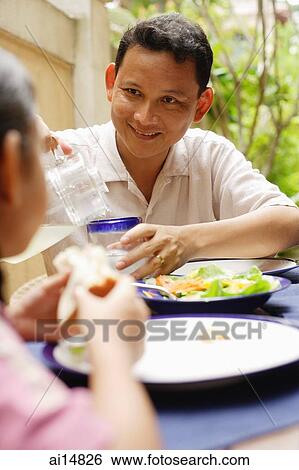 Stock Photograph - Man pouring drink, portrait. Fotosearch