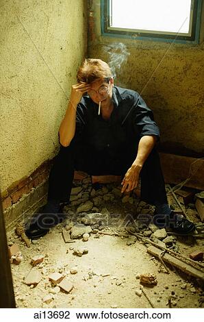 Man sitting corner, hand on head, smoking View Large Photo Image Stock Image - Man sitting corner, hand on head, smoking. Fotosearch