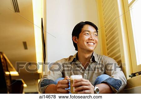 Man sitting, holding mug of coffee, smiling View Large Photo Image Stock Photo - Man sitting, holding mug of coffee, smiling. Fotosearch