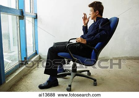 Man sitting in empty room, looking out of window View Large Photo Image Stock Photo - Man sitting in empty room, looking out of window. Fotosearch