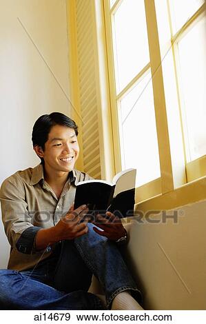Man sitting, reading book, smiling View Large Photo Image Stock Photo - Man sitting, reading book, smiling. Fotosearch