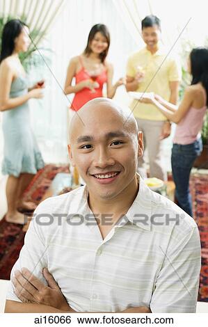 Man smiling at camera, people in the background View Large Photo Image Stock Photograph - Man smiling at camera, people in the background. Fotosearch