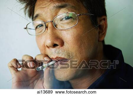 Stock Photo - Man smoking cigarette, headshot. Fotosearch