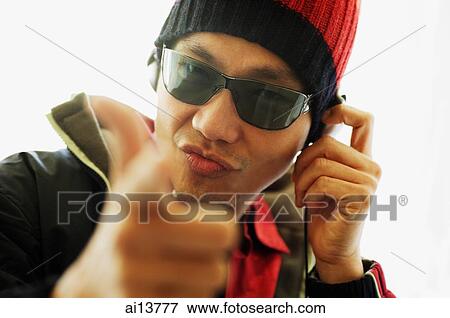 Man wearing headphones and sunglasses, looking at camera View Large Photo Image Stock Photo - Man wearing headphones and sunglasses, looking at camera. Fotosearch