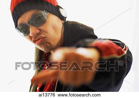 Man wearing headphones and sunglasses, pointing at camera View Large Photo Image Stock Photograph - Man wearing headphones and sunglasses, pointing at camera. Fotosearch