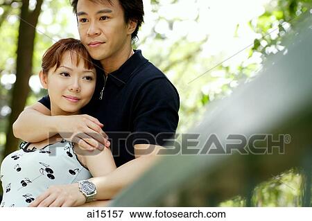 Man with arm around woman, looking away View Large Photo Image Stock Photo - Man with arm around woman, looking away. Fotosearch