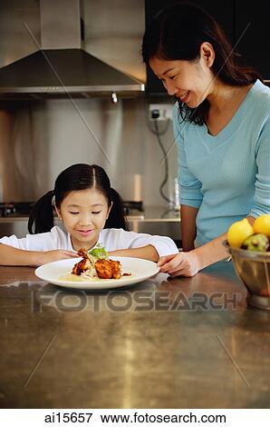 Mother and daughter looking at plate of food, smiling View Large Photo Image Stock Photo - Mother and daughter looking at plate of food, smiling. Fotosearch