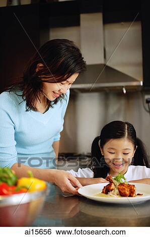 Mother and daughter looking at plate of food View Large Photo Image Stock Photograph - Mother and daughter looking at plate of food. Fotosearch