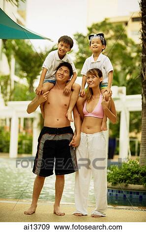 Mother and father carrying children on shoulder View Large Photo Image Stock Photo - Mother and father carrying children on shoulder. Fotosearch