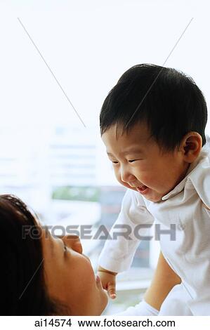 Mother carrying baby boy, face to face View Large Photo Image Picture - Mother carrying baby boy, face to face. Fotosearch
