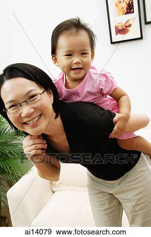 Stock Photo - Mother carrying daughter on back. Fotosearch