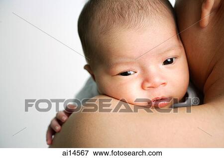 Stock Photo - Mother carrying infant, over the shoulder view. Fotosearch