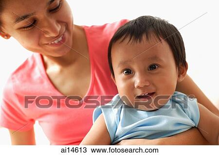 Mother holding baby boy, both smiling, portrait View Large Photo Image Stock Image - Mother holding baby boy, both smiling, portrait. Fotosearch