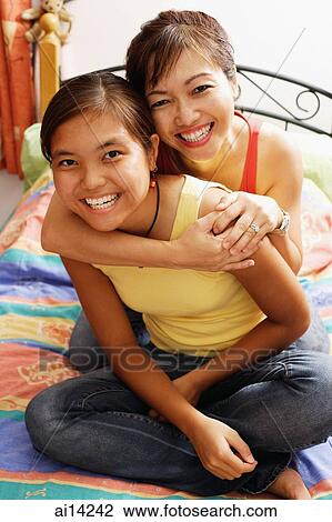 Mother hugging daughter, both smiling, looking at camera View Large Photo Image Stock Image - Mother hugging daughter, both smiling, looking at camera. Fotosearch
