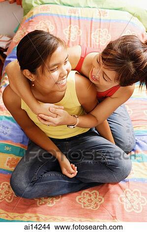 Mother hugging daughter, looking at each other View Large Photo Image Picture - Mother hugging daughter, looking at each other. Fotosearch