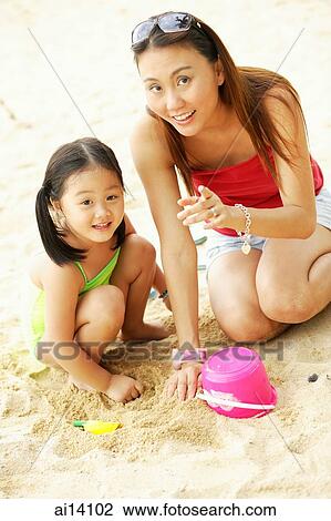 Mother with one child on beach, looking at camera View Large Photo Image Stock Image - Mother with one child on beach, looking at camera. Fotosearch