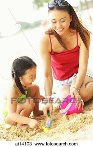 Mother with one child on beach, playing with sand View Large Photo Image Stock Image - Mother with one child on beach, playing with sand. Fotosearch