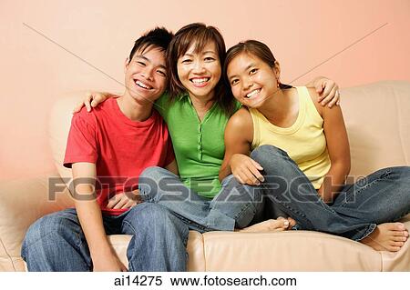 Stock Photography - Mother with son and daughter, sitting on sofa, smiling. Fotosearch
