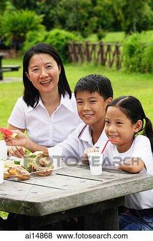 Mother with two children, sitting at picnic table, portrait View Large Photo Image Stock Photo - Mother with two children, sitting at picnic table, portrait. Fotosearch