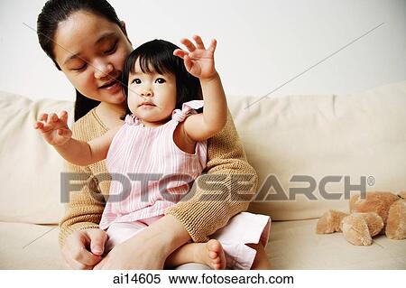 Stock Photography - Mother with young daughter on sofa. Fotosearch